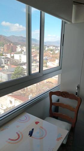 una mesa y una silla frente a una ventana en Departamento Dean Funes 520 Salta en Salta