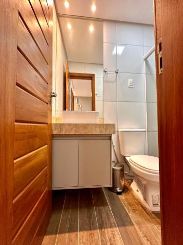 a bathroom with a toilet and a sink and a mirror at Acoara Beco Doce in Jericoacoara