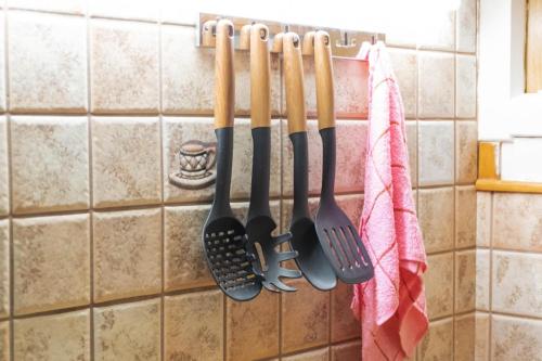 a bunch of utensils hanging on a rack in a kitchen at Cozy Central Home Heraklion in Heraklio