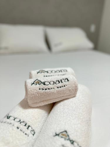a stack of towels sitting on a bed at Acoara Beco Doce in Jericoacoara