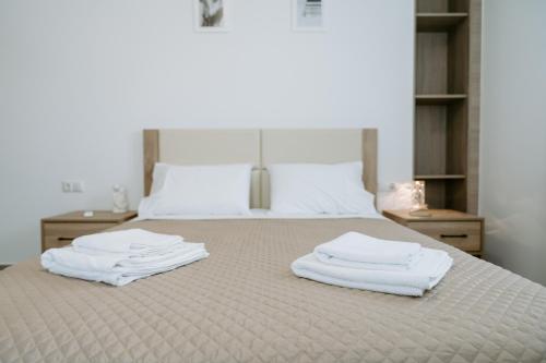 una camera da letto con un letto e asciugamani bianchi di Apartments Christina a Perdika