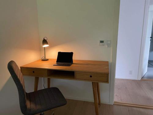 a desk with a laptop and a lamp on it at BRAND NEW FLAT IN CENTRAL KLAKSVÍK in Klaksvík