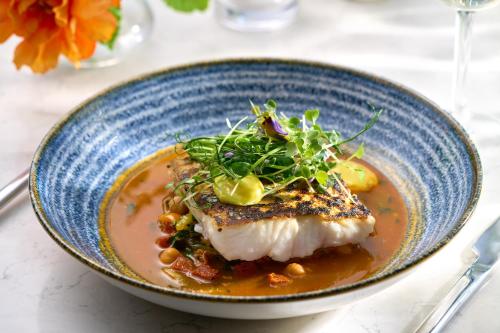 a blue bowl of food with a piece of fish at Tulfarris Hotel and Golf Resort in Blessington
