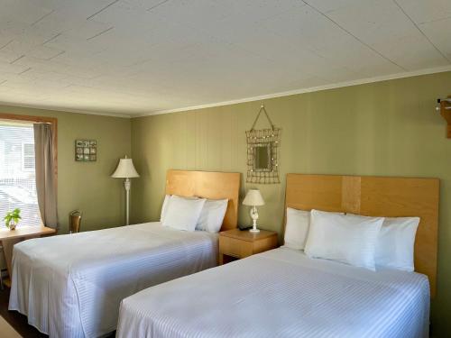 duas camas num quarto com paredes verdes em Moontide Motel, Apartments, and Cabins em Old Orchard Beach