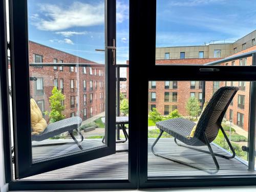 dos sillas sentadas en un porche mirando por la ventana en Icona 20 - city centre apartment, en York
