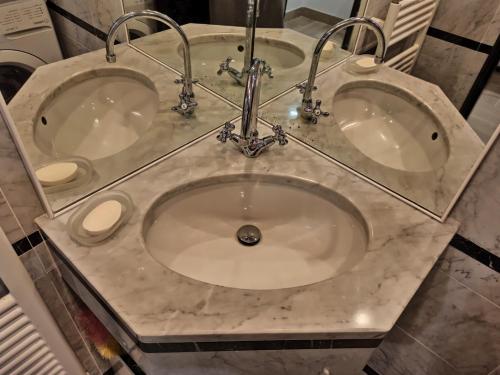 two sinks in a bathroom with a marble counter top at CASA ODELLO suite and the sea in Bordighera