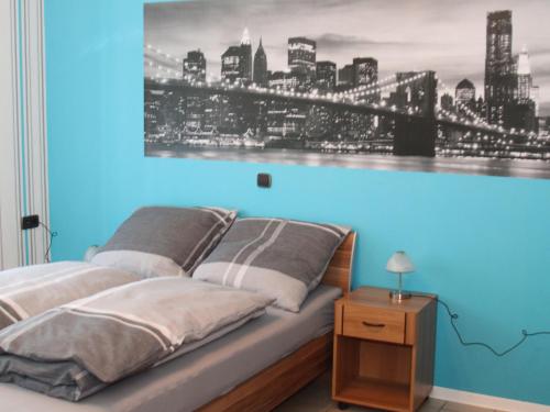 a bed with a blue wall with a picture of a city at Ferienwohnung Marquis in Bad Sobernheim