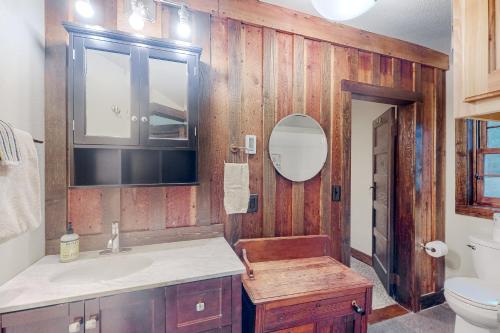 a bathroom with wooden walls and a sink and a toilet at War Eagle Homestead Cabin in Rambo Riviera