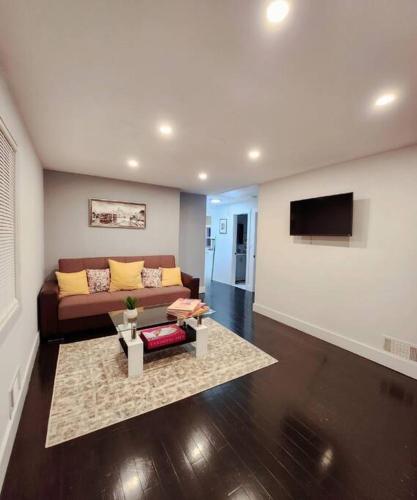 a living room with a couch and a tv at Entire Modern 1 Fam house/ 7 min walk to NYC Train in Tuckahoe