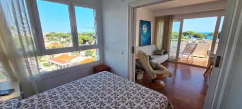 1 dormitorio con cama y vistas a un balcón en Miramar Serveis - Vistas Increíbles a la Bahía Terraza y Parking, en Cambrils