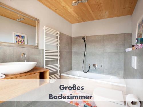 ein Badezimmer mit einer weißen Badewanne und einem Waschbecken in der Unterkunft Bio, Natur, Zirbe, Seenähe, Bergblick Bleibe am Berg II in Schliersee