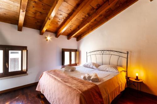 - une chambre avec un grand lit dans une pièce dotée de plafonds en bois dans l'établissement La Terrazza Apartment - Smart Holiday, à Mantoue
