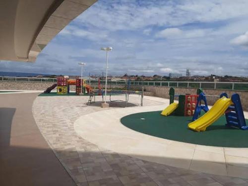 un parque infantil con toboganes y equipo de juegos en un edificio en Apartamento confortável, localização extra -recepção 24h- Varanda com vista panorâmica, en Juazeiro do Norte