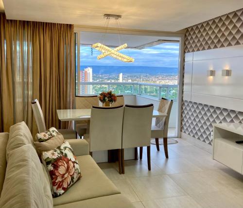 uma sala de estar com um sofá e uma sala de jantar em Apartamento confortável com uma bela vista - lagoa seca Juazeiro em Juazeiro do Norte