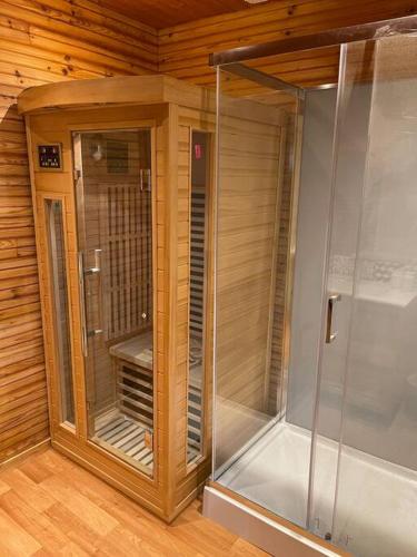 Cette chambre dispose de murs en bois et d'une douche à l'italienne. dans l'établissement Romantique chalet avec sauna et jacuzzi extérieur, à Arthon