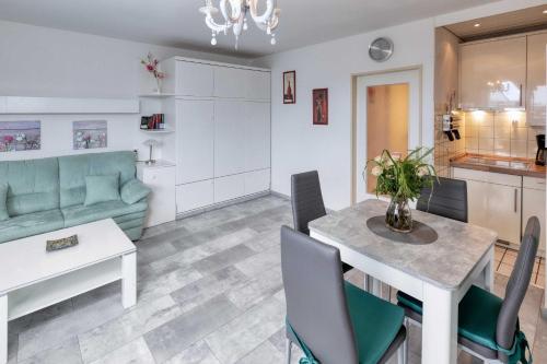 een keuken en woonkamer met een tafel en een bank bij Terrassenhaus, FeWo 66 in Duhnen
