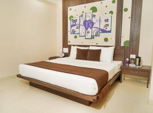 ein Schlafzimmer mit einem großen Bett und einem Gemälde an der Wand in der Unterkunft Hotel Yash Regency in Jaipur