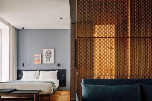 a bedroom with a bed and a blue chair at Hotel Hotel - Member of Design Hotels in Lisbon