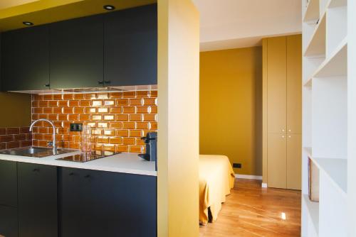 a kitchen with a sink and a brick wall at Le Grand Maulnes in Paris