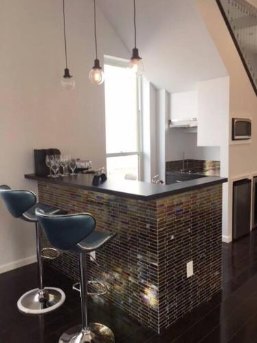a kitchen with two bar stools and a counter at Luxury three story apartment in SHORT NORTH in Columbus
