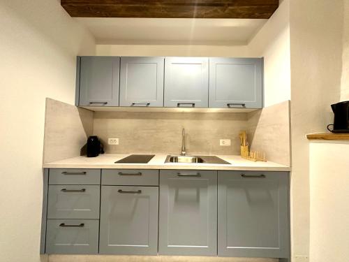 a kitchen with white cabinets and a sink at Apartments Angela in Piran