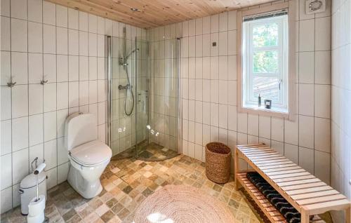 a bathroom with a toilet and a shower and a bench at Nice Home In Nord-torpa With 4 Bedrooms in Nord Torpa
