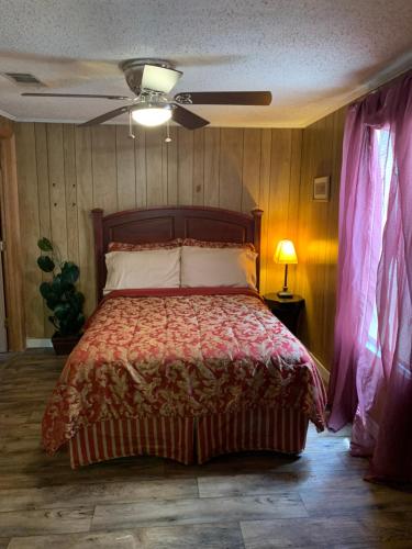 een slaapkamer met een bed en een plafondventilator bij WandaBrooks Place in Pine Bluff