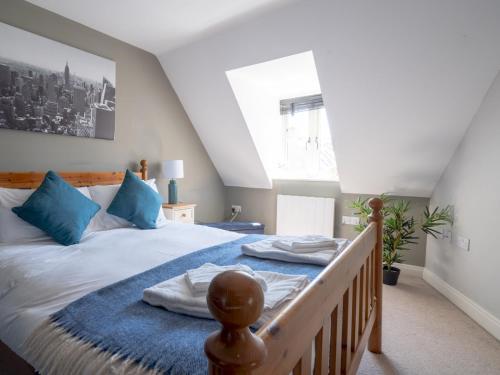 a bedroom with a large bed with blue pillows at Pass the Keys Lovely 4 bedroom family home with garden parking in Cheltenham