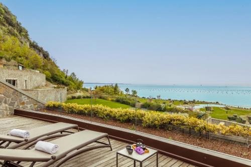 a balcony with chairs and a view of the ocean at Tivoli Portopiccolo Sistiana Wellness Resort & Spa in Sistiana