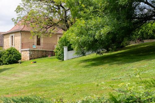 a house with a grassy yard with a fence at Les Gîtes de JueVince in Issac