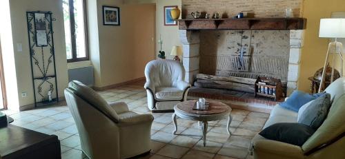 a living room with two chairs and a fireplace at Les Gîtes de JueVince in Issac