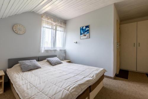 - une chambre avec un grand lit et une fenêtre dans l'établissement Pokoje gościnne Anna, à Rewa