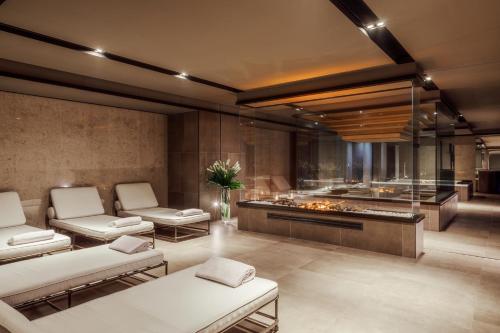 a lobby with white chairs and a fire place at Tivoli Portopiccolo Sistiana Wellness Resort & Spa in Sistiana