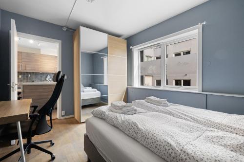 a bedroom with a bed and a desk and a window at Modern - Work friendly - Quiet area in Bergen