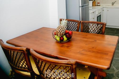 a wooden table with a bowl of fruit on it at Pefkohori Pegasus MoodSolutions Living in Pefkohori