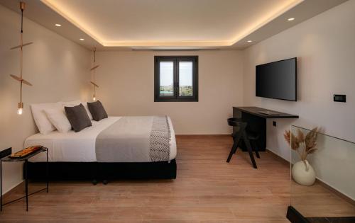 a bedroom with a bed and a flat screen tv at Iphimedeia Luxury Hotel & Suites in Naxos Chora