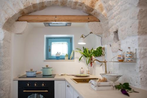 een keuken met een stenen muur en een aanrecht bij Trulli Ericla Resort in Castellana Grotte