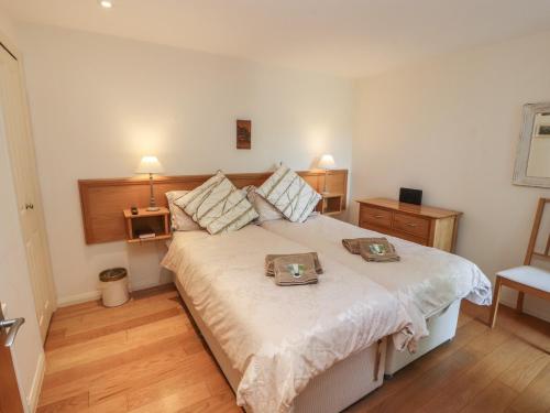 a bedroom with a large bed with two trays on it at Ash Meadows in Carnforth