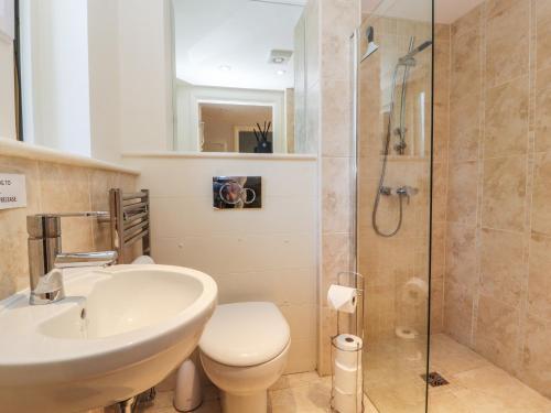 a bathroom with a sink and a toilet and a shower at Ash Meadows in Carnforth