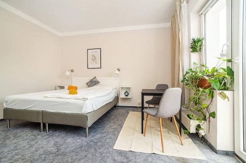a bedroom with a bed and a table and a chair at Cosy studio with terrace by tram in Prague