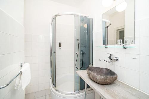 a bathroom with a sink and a glass shower at Cosy studio with terrace by tram in Prague