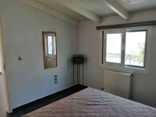 a white room with a bed and two windows at Manolis Loft in Piraeus