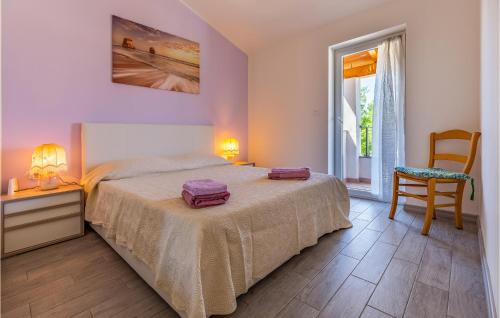 ein Schlafzimmer mit einem Bett, einem Stuhl und einem Fenster in der Unterkunft 2 Bedroom Cozy Home In Filipana in Filipana