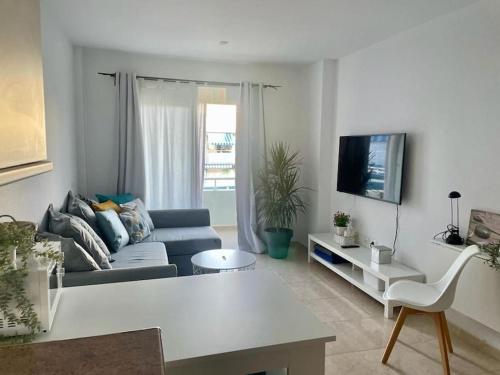 a living room with a couch and a tv at Espacio tranquilo cerca del mar in Santa Cruz de Tenerife