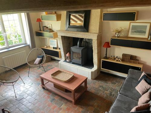 a living room with a fireplace and a couch at Loue charmante maison de vacances à 10 mns de Bellême (61) 
