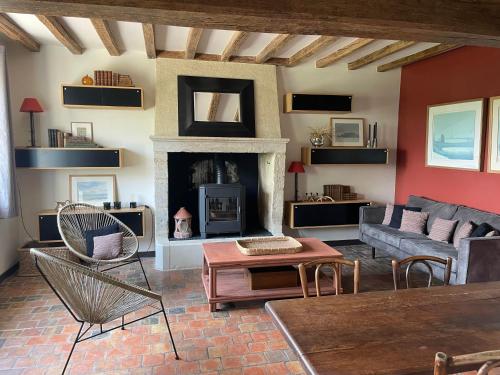 a living room with a couch and a fireplace at Loue charmante maison de vacances à 10 mns de Bellême (61) in Saint-Martin-du-Vieux-Bellême