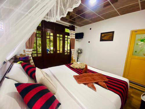 a bedroom with a large white bed with red and black pillows at Home Away Ella in Ella