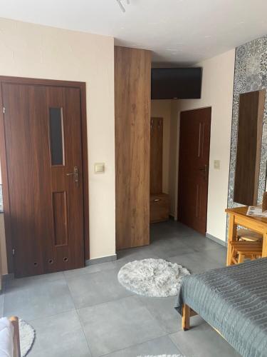 a bedroom with two wooden doors and a bed at U Bizioma in Murzasichle