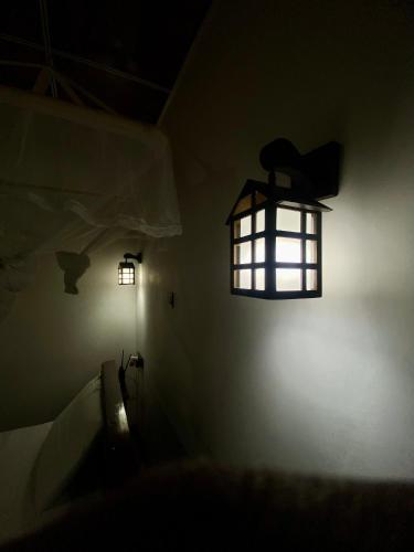 a dark room with a light fixture on the wall at Home Away Ella in Ella