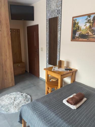 a bedroom with a bed and a desk and a television at U Bizioma in Murzasichle